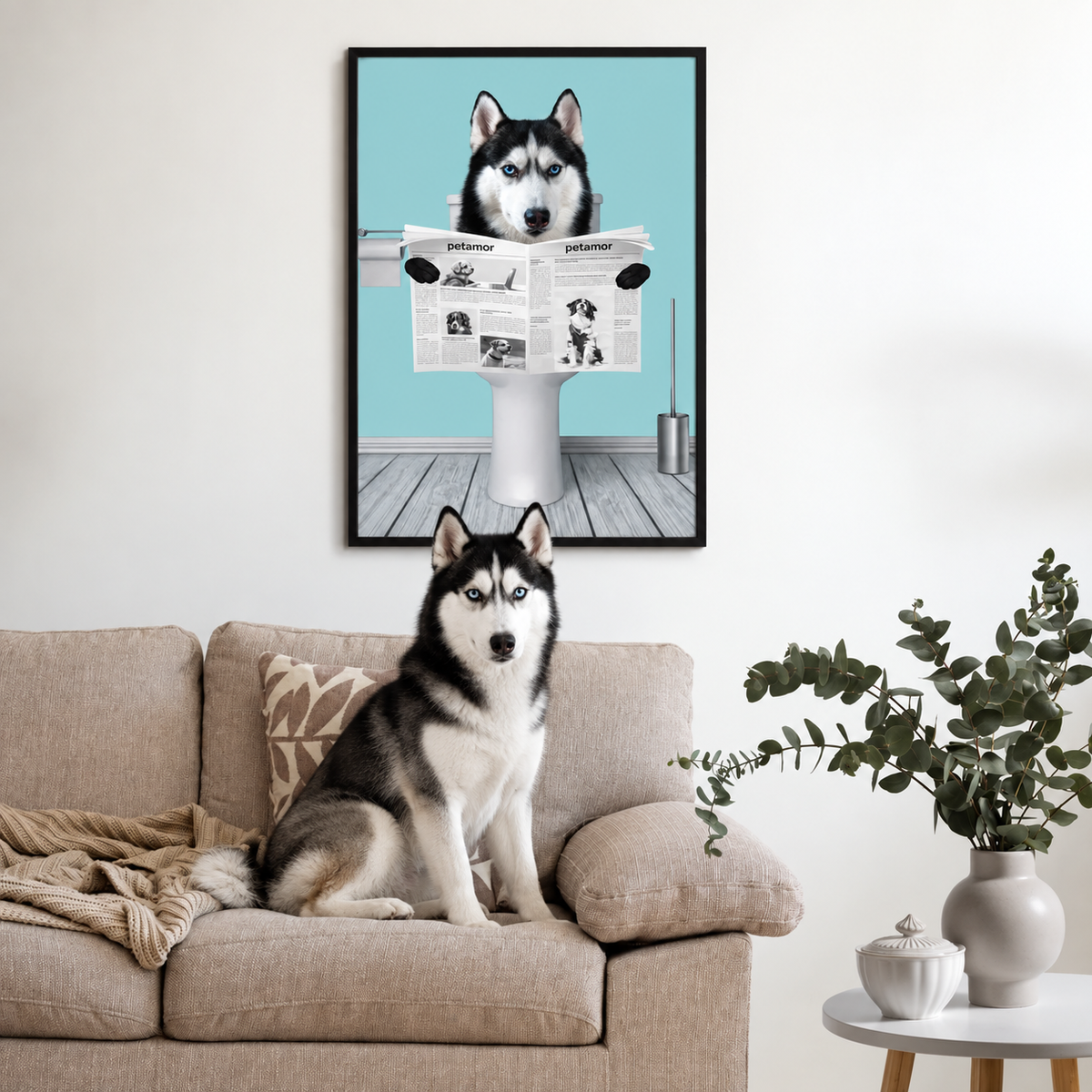 Poster mit einem Hund, der eine Zeitung liest, im Wohnraum über einem Sofa. Hund sitzt auf der Couch.