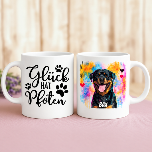 Weiße Tasse mit graffitistischen Hundemotiv und der Aufschrift "Glück hat Pfoten" auf einer Seite.