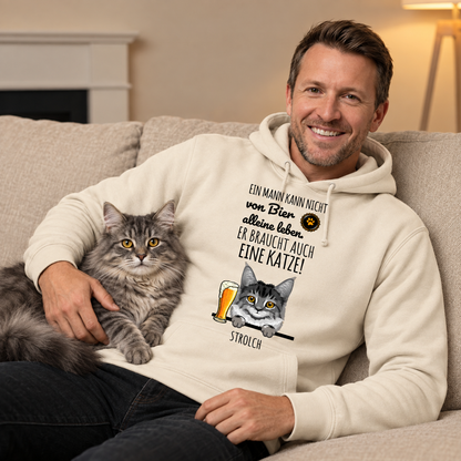 Personalisierter beiger Hoodie mit Schriftzug und Katzenmotiv, getragen von einem Mann mit Katze auf dem Schoß.