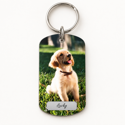 Personalisierter Schlüsselanhänger mit Foto eines Hundes und graviertem Namen auf silberner Fläche.