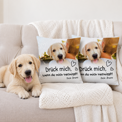 Zwei personalisierte Kissen mit aufgedrucktem Text und Bild eines Hundes, liegend auf einem hellen Sofa.