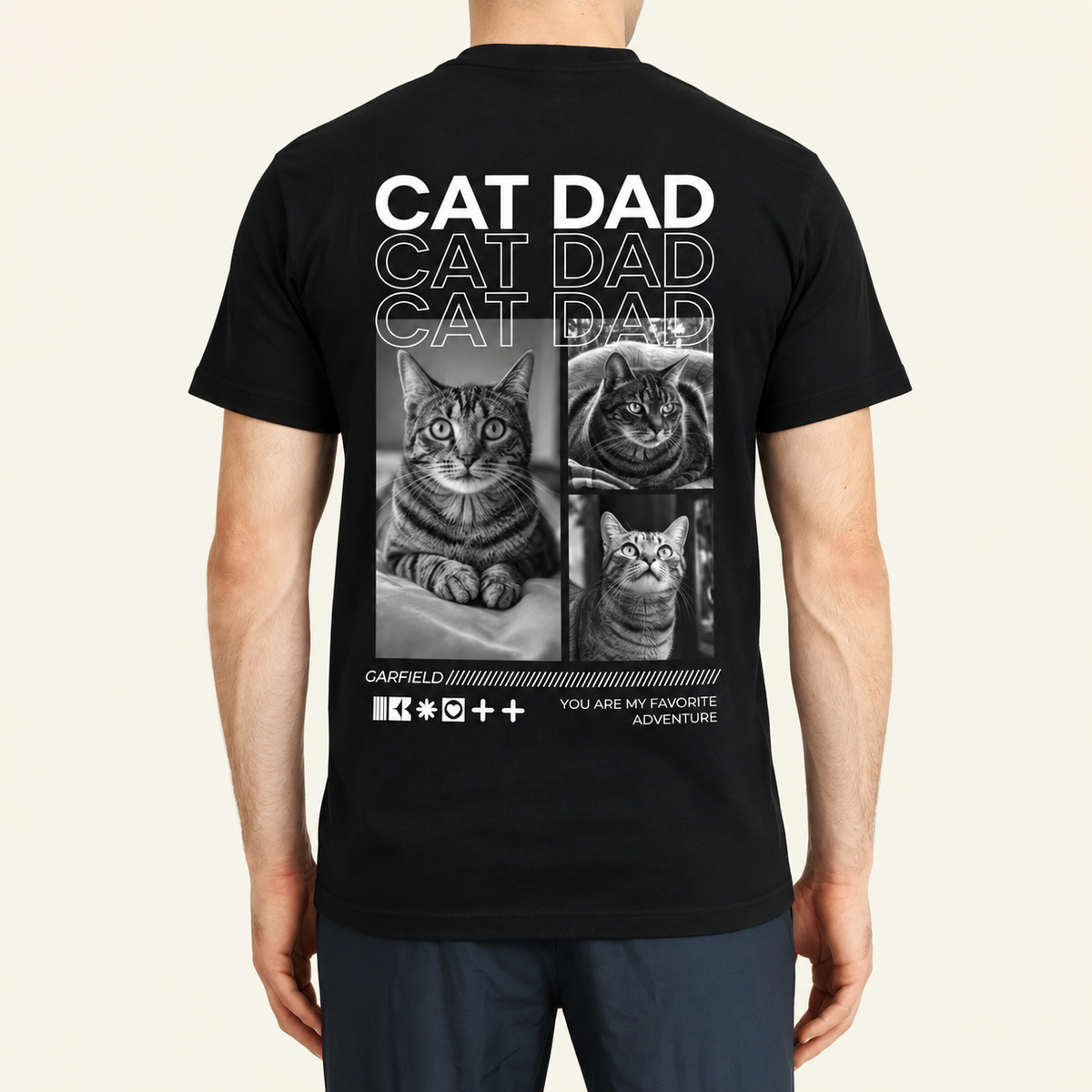 Schwarzes T-Shirt mit dem Schriftzug "Cat Dad" und Fotos von Katzen auf der Rückseite.