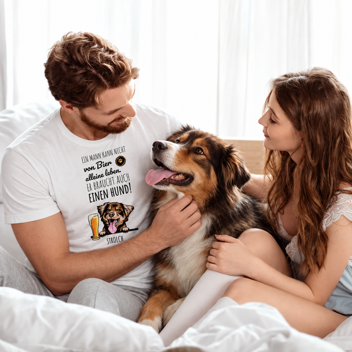 Personalisiertes T-Shirt in Weiß mit Hundemotiv und Spruch über Bier, getragen von einem Mann im Bett mit Hund und Frau.