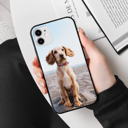 Personalisierte Handyhülle mit Foto eines Hundes, in schwarz, gehalten von einer Person.