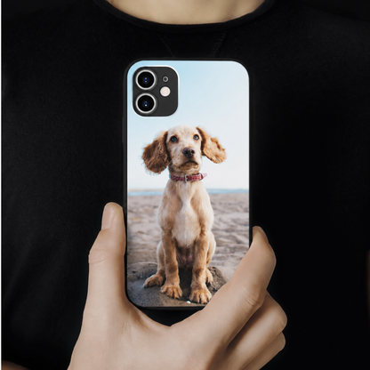 Personalisierte Handyhülle mit einem Foto eines Hundes, gehalten von einer Person.