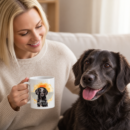 Person, die eine weiße Tasse mit Haustierporträt in der Hand hält, neben einem Hund sitzend.