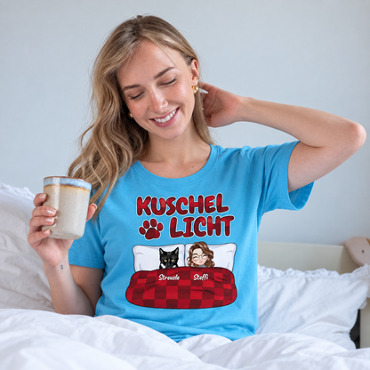 Türkisfarbenes T-Shirt mit Aufdruck "Kuschel Licht", abgebildet auf einer lächelnden Frau im Bett.