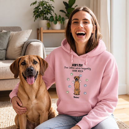 Person mit rosa Hoodie, bedruckt mit Spruch und Hundemotiv, sitzt auf dem Boden neben einem Hund.