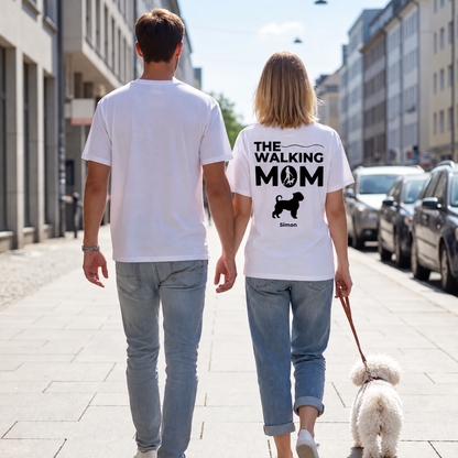 Zwei Personen tragen weiße T-Shirts mit dem Aufdruck "THE WALKING MOM" und einem Hund, auf einer Straße.