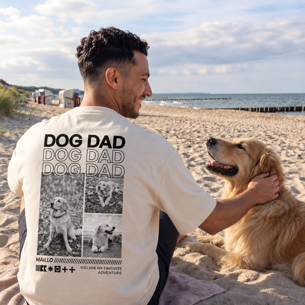 Beige T-Shirt mit dem Aufdruck "DOG DAD", getragen von einem Mann am Strand, mit einem golden retriever.