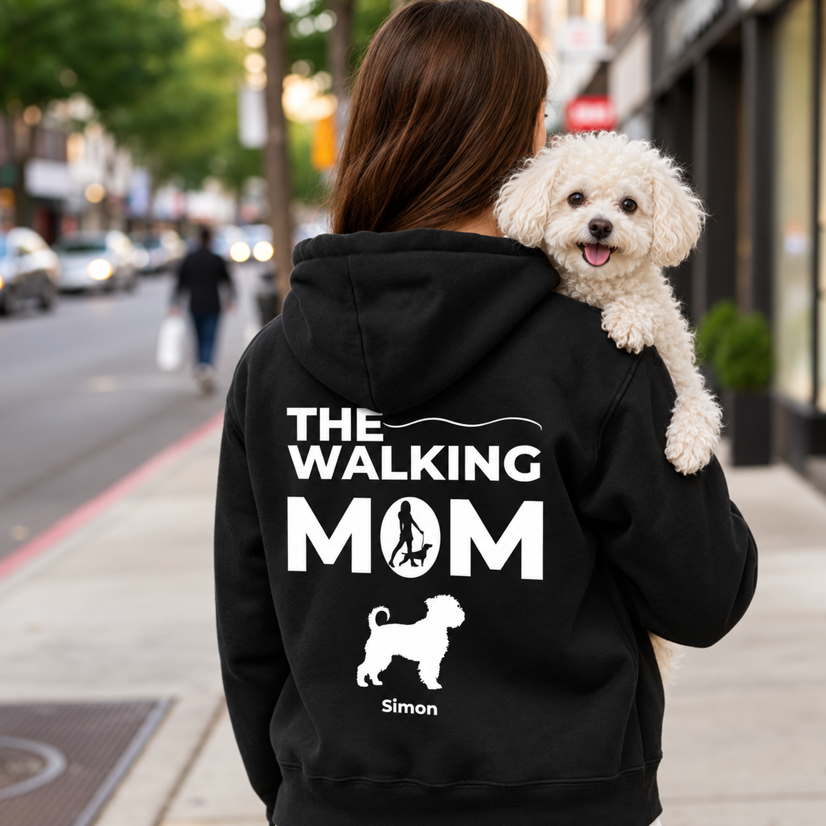 Schwarzer Hoodie mit personalisiertem Aufdruck "THE WALKING MOM" und Hundemotiv. Person trägt einen Hund.