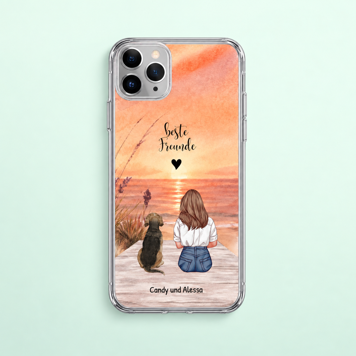 Personalisierte transparente Handyhülle mit Illustration eines Mädchens und Hund am Strand bei Sonnenuntergang.