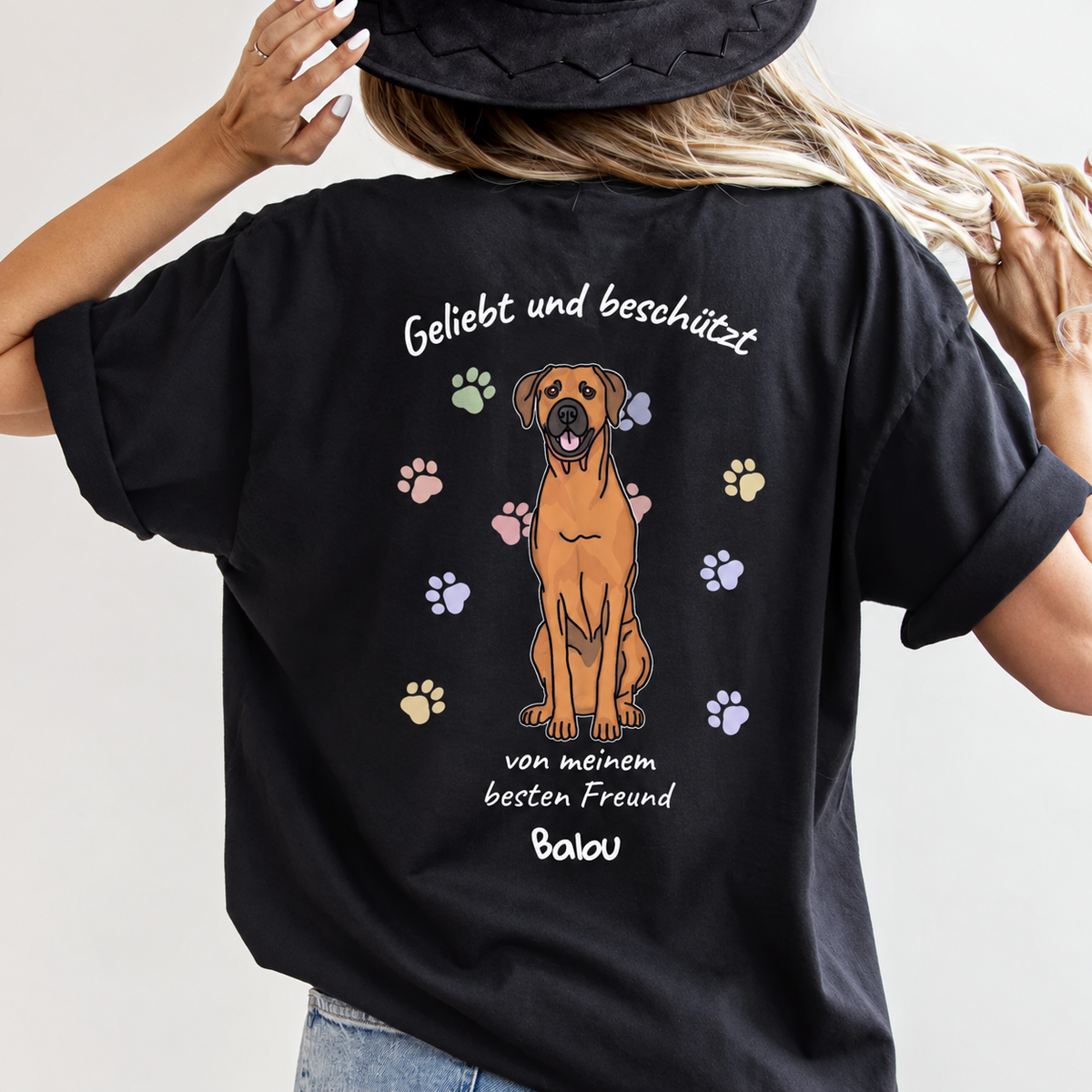 Schwarzes T-Shirt mit hundeillustration und Schriftzug "Geliebt und beschützt" auf der Rückseite.
