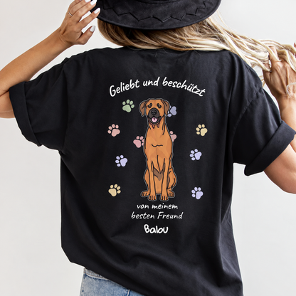 Schwarzes T-Shirt mit hundeillustration und Schriftzug "Geliebt und beschützt" auf der Rückseite.