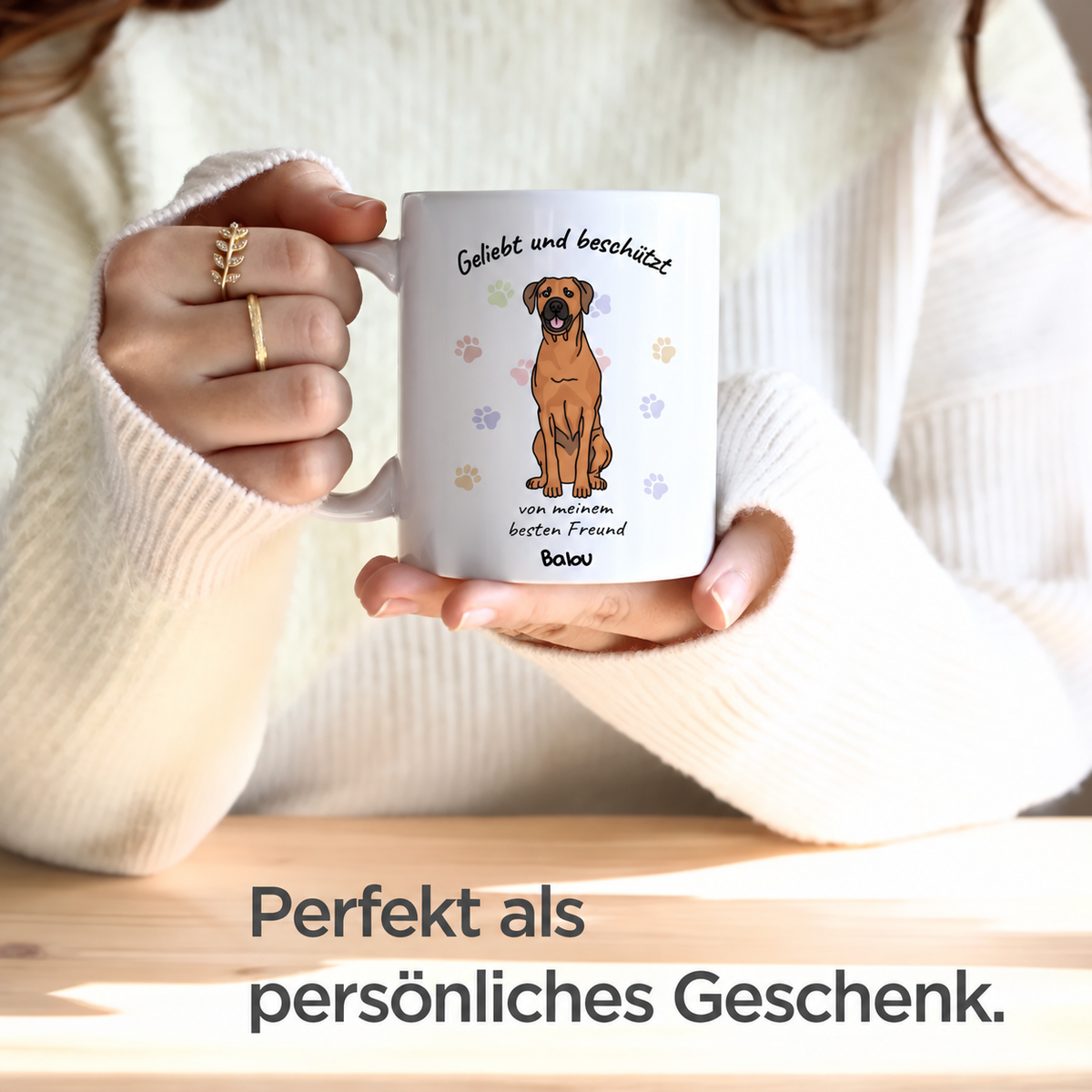 Weiße Tasse mit Aufdruck eines Hundes und den Worten "Geliebt und beschützt" sowie personalisierbarem Namen.