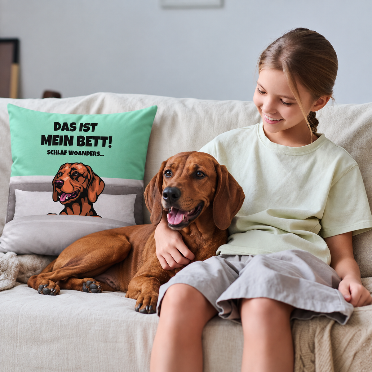 Personalisiertes Kissen mit Hundemotiv in mintgrün und grau, zusammen mit einem Mädchen und ihrem Hund auf dem Sofa.