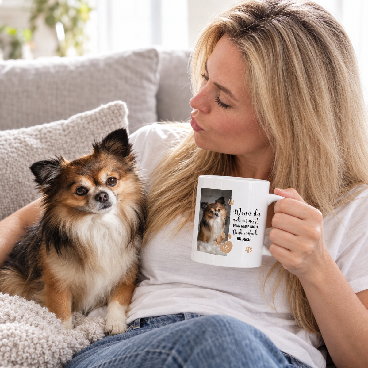 Personalisierte Tasse mit Text und Foto eines Hundes, gehalten von einer Frau auf einem Sofa.