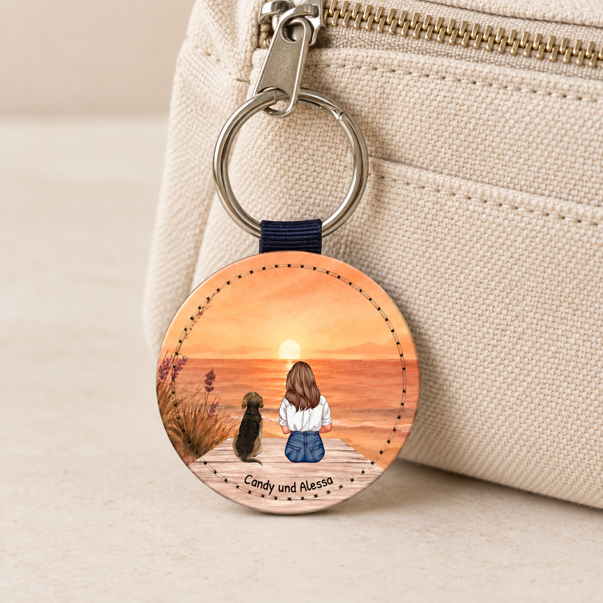 Personalisierter Schlüsselanhänger mit Illustration einer Frau und einem Hund vor einem Sonnenuntergang.