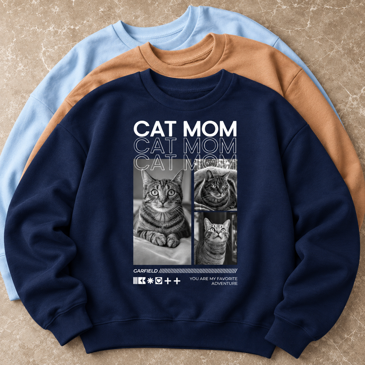 Dunkelblaues Sweatshirt mit Katzenmotiven und "CAT MOM" Schriftzug in Großbuchstaben.