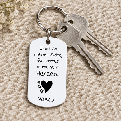 Personalisierter Schlüsselanhänger aus Metall mit weißer Oberfläche und schwarzer Schrift.