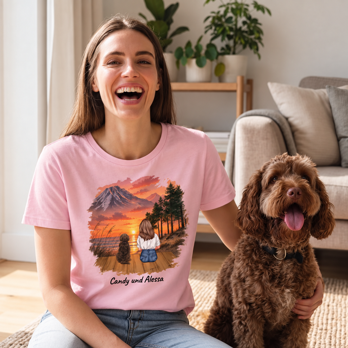 Pinkes T-Shirt mit personalisiertem Druck einer Frau und zwei Hunden vor einer Landschaft mit Sonnenuntergang.