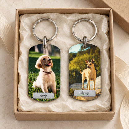 Personalisierter Schlüsselanhänger mit zwei Fotos von Hunden in Geschenkverpackung.