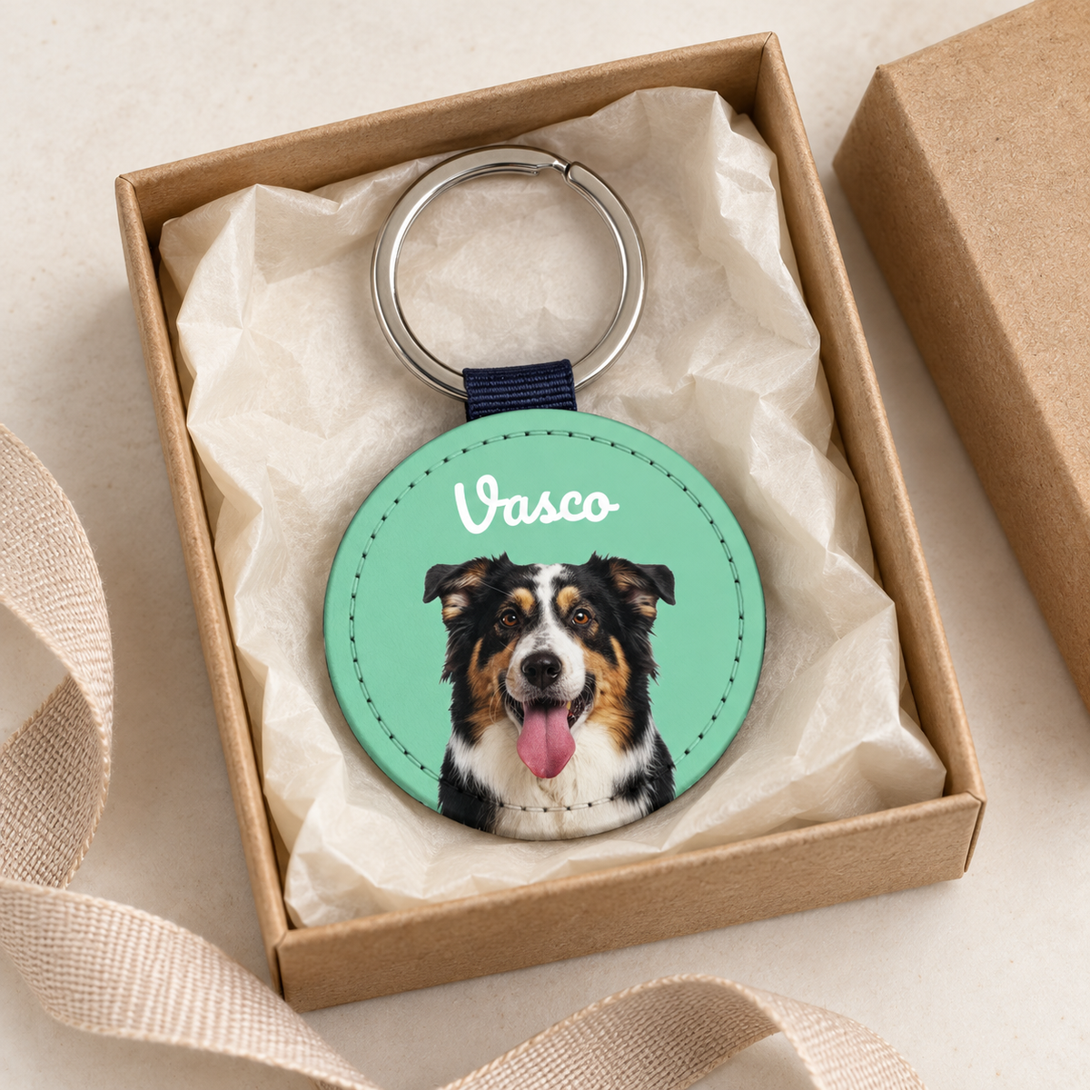 Personalisierter Schlüsselanhänger mit Hundeporträt auf grünem Hintergrund, verpackt in Geschenkbox.