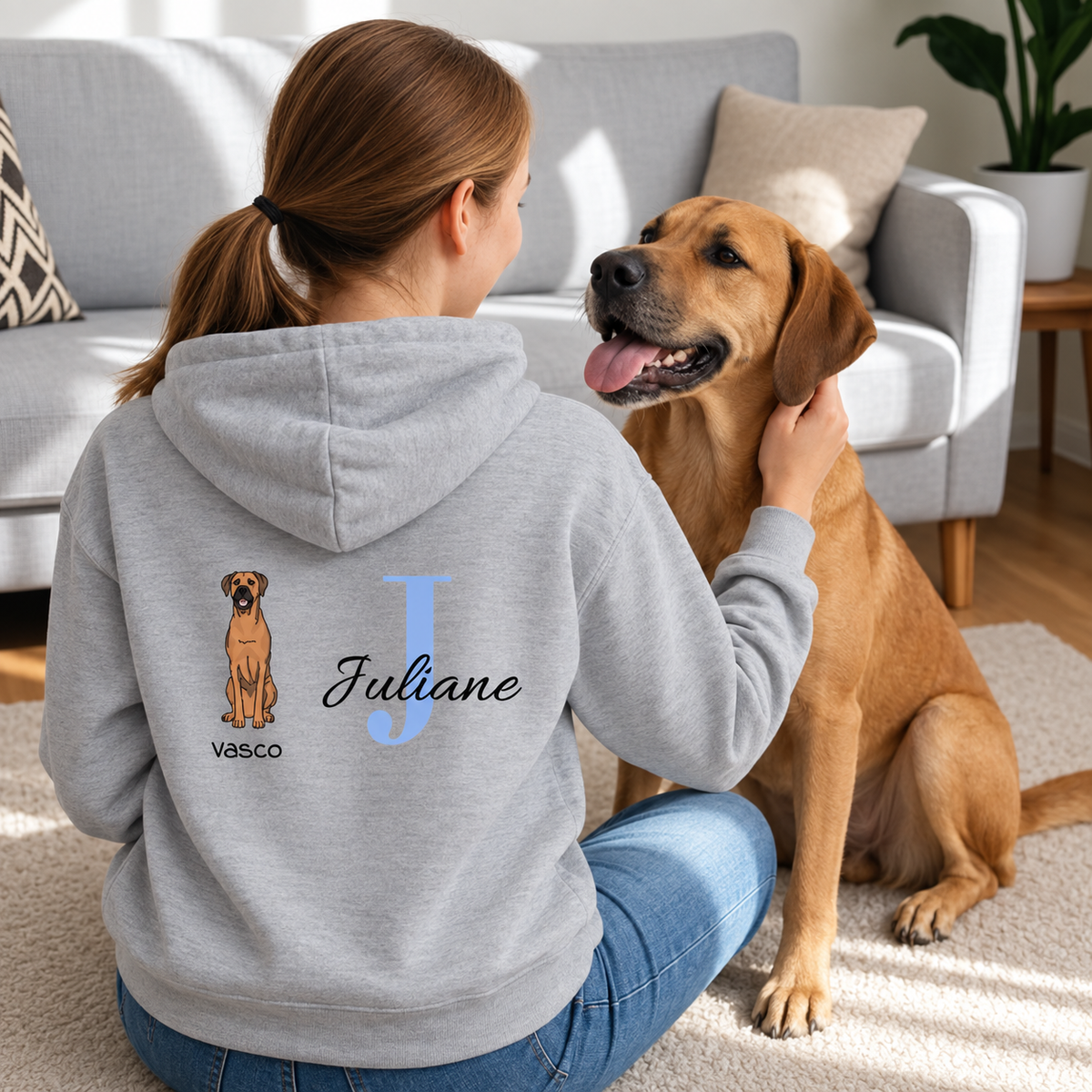 Grau hoodie mit personalisierter Rückseite: Hund und Name "Juliane" in blauer Schrift.