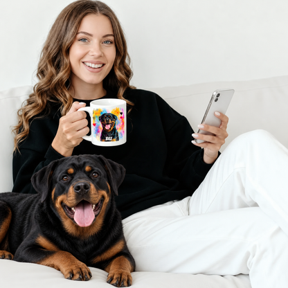 Person, die eine personalisierte Tasse mit Rottweiler-Motiv hält, sitzt auf einer Couch neben einem Rottweiler.