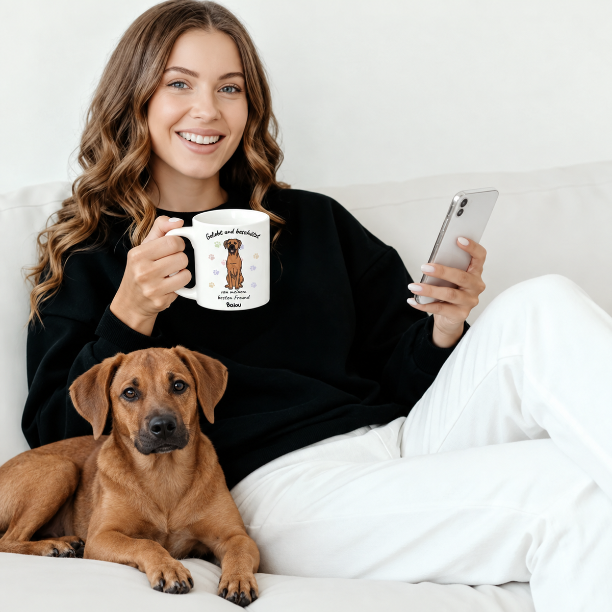 Personalisierte Tasse mit aufgedrucktem Hundemotiv und Text, Frau in schwarzem Pullover, sitzend mit Hund.
