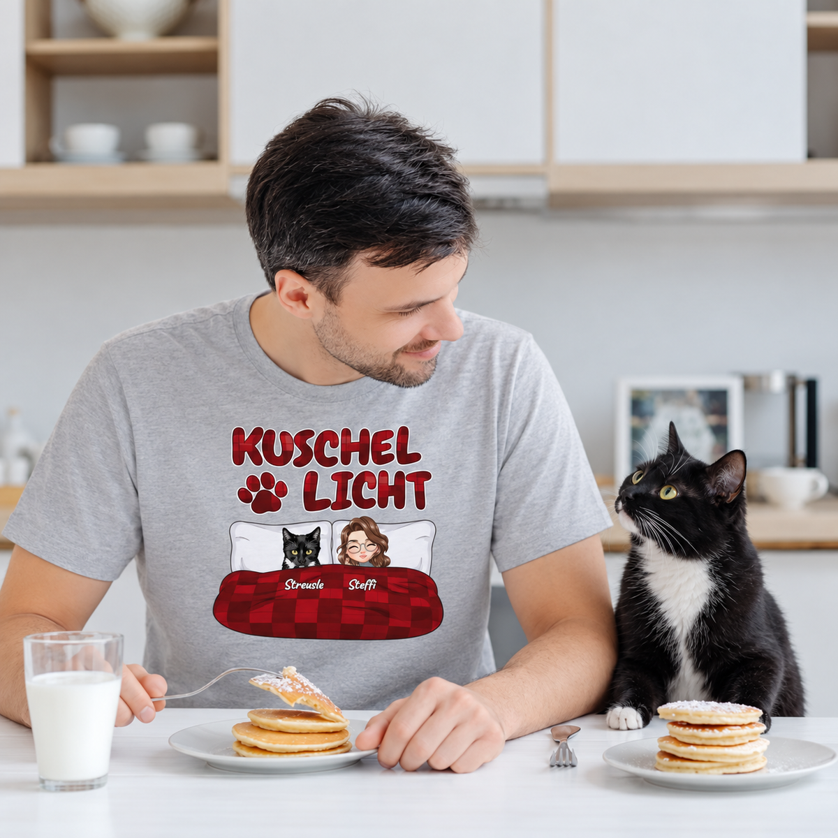 Personalisierte graue T-Shirt mit dem Aufdruck "Kuschel Licht" und einer Cartoon-Darstellung von Katze und Person.
