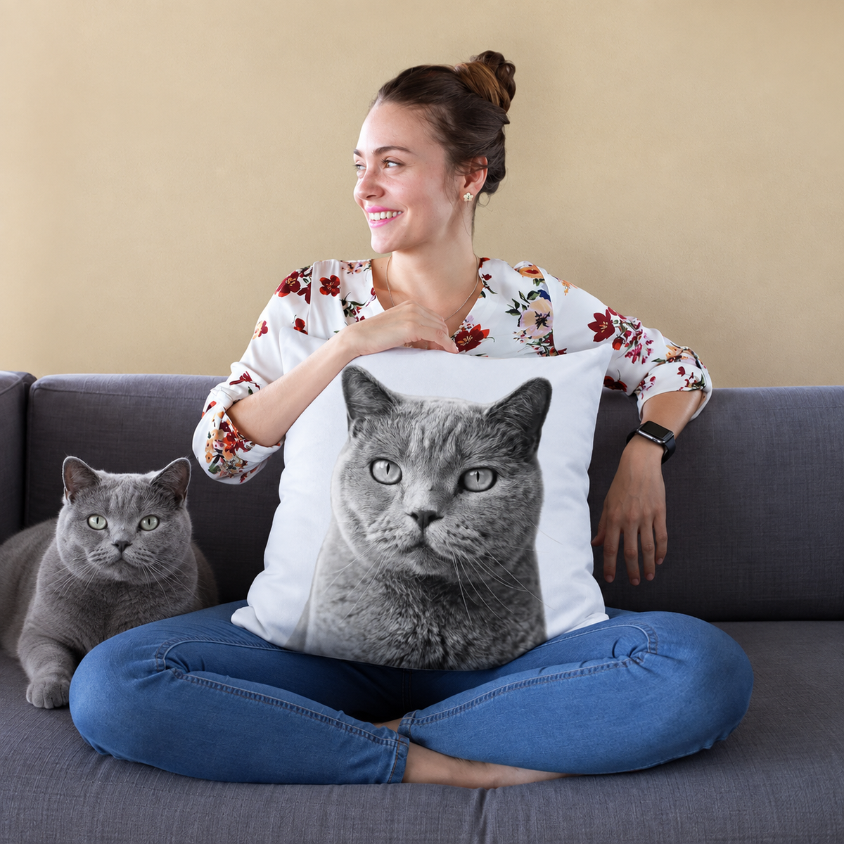 Kissen mit Katzenportrait in Schwarz-Weiß, Person sitzt auf einem Sofa und hält das Kissen.