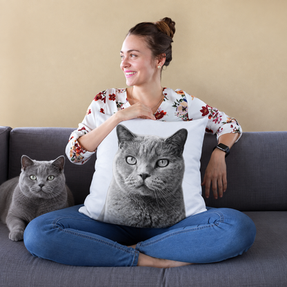 Kissen mit Katzenportrait in Schwarz-Weiß, Person sitzt auf einem Sofa und hält das Kissen.