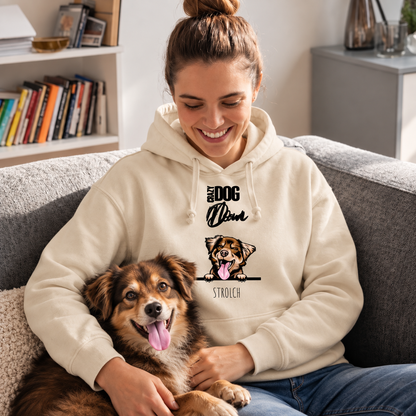 Beige Hoodie mit Stickmotiv „Crazy Dog Dad“ und Hund, Person sitzt auf einer Couch und hält ihren Hund.