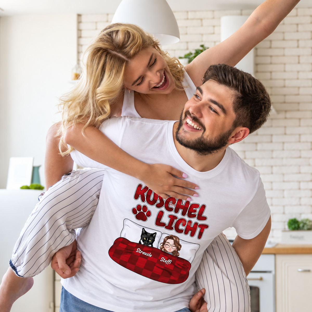 Weißes T-Shirt mit dem Aufdruck "Kuschel Licht" und cartoonartigen Figuren eines Paares und einer Katze.