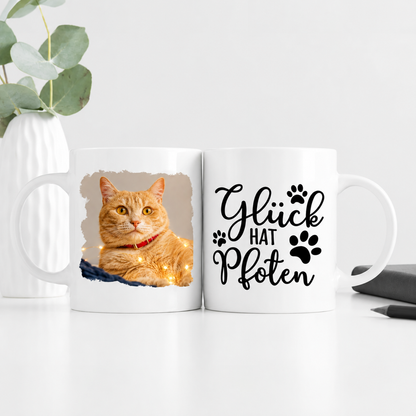 Personalisierte Tasse mit Katzenfoto und dem Schriftzug "Glück hat Pfoten" in Schwarz.