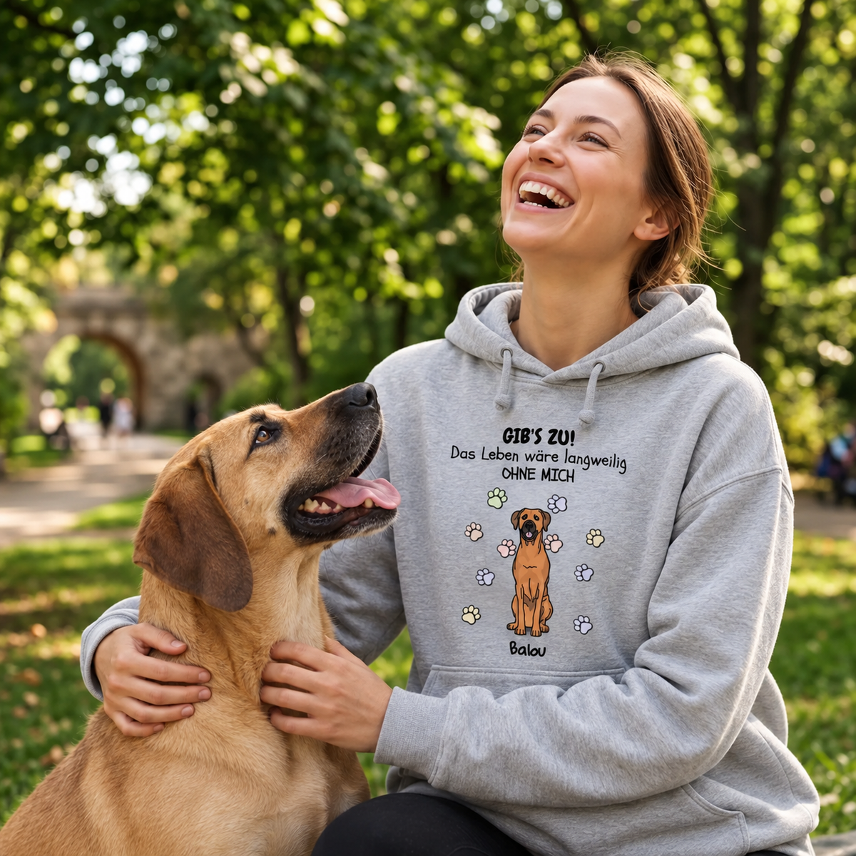 Grauer Hoodie mit Aufdruck „Das Leben wäre langweilig ohne mich“ und Hundemotiv, getragen von einer lächelnden Frau.