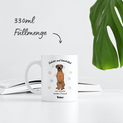Personalisierte weiße Tasse mit dem Aufdruck „Geliebt und beschützt“ und einem Hundemotiv. Füllmenge 330ml.