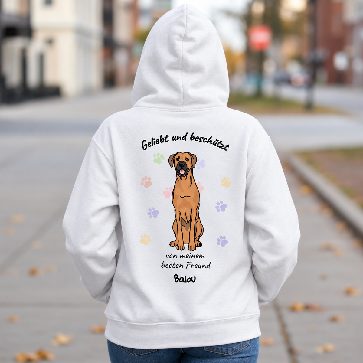 Weißer Hoodie mit Hundemotiv und Aufschrift „Geliebt und beschützt“ auf der Rückseite.