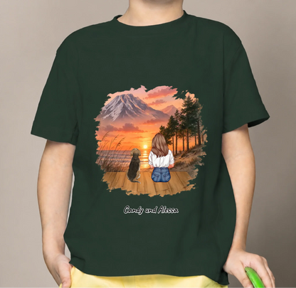 Dunkelgrünes Kinder T-Shirt mit buntem Print von einem Mädchen und einem Hund vor Sonnenuntergang.