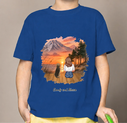 Blaues Kinder T-Shirt mit Illustration von einem Mädchen und Hund, die einen Sonnenuntergang betrachten.