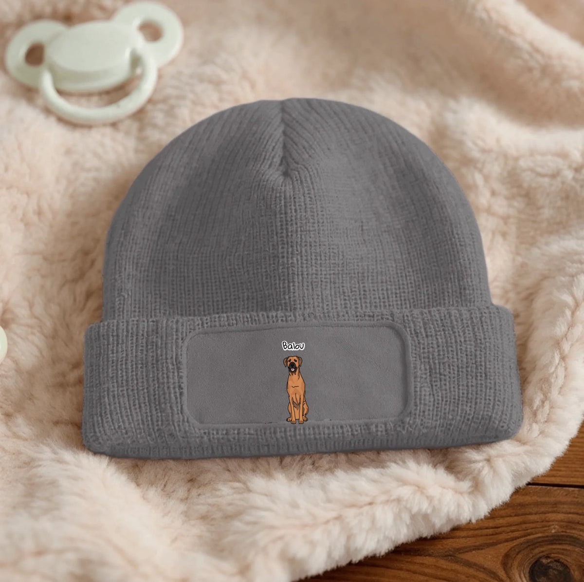 Grau gestrickte Beanie mit personalisiertem Aufnäher und Hundemotiv.