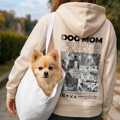 Beige Hoodie mit "Dog Mom"-Aufdruck auf dem Rücken, Person trägt weißen Beutel mit Pomeranian-Hund.