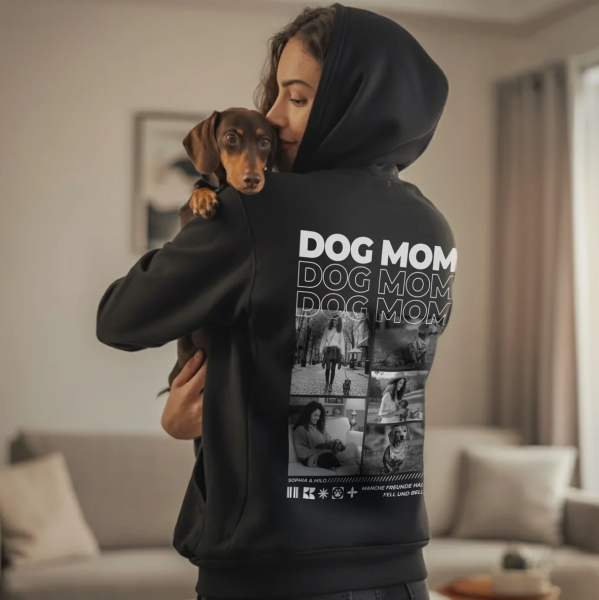 Schwarzer Hoodie mit Aufdruck "DOG MOM" und Fotos von Hunden auf der Rückseite. Person trägt einen Hund auf dem Arm.