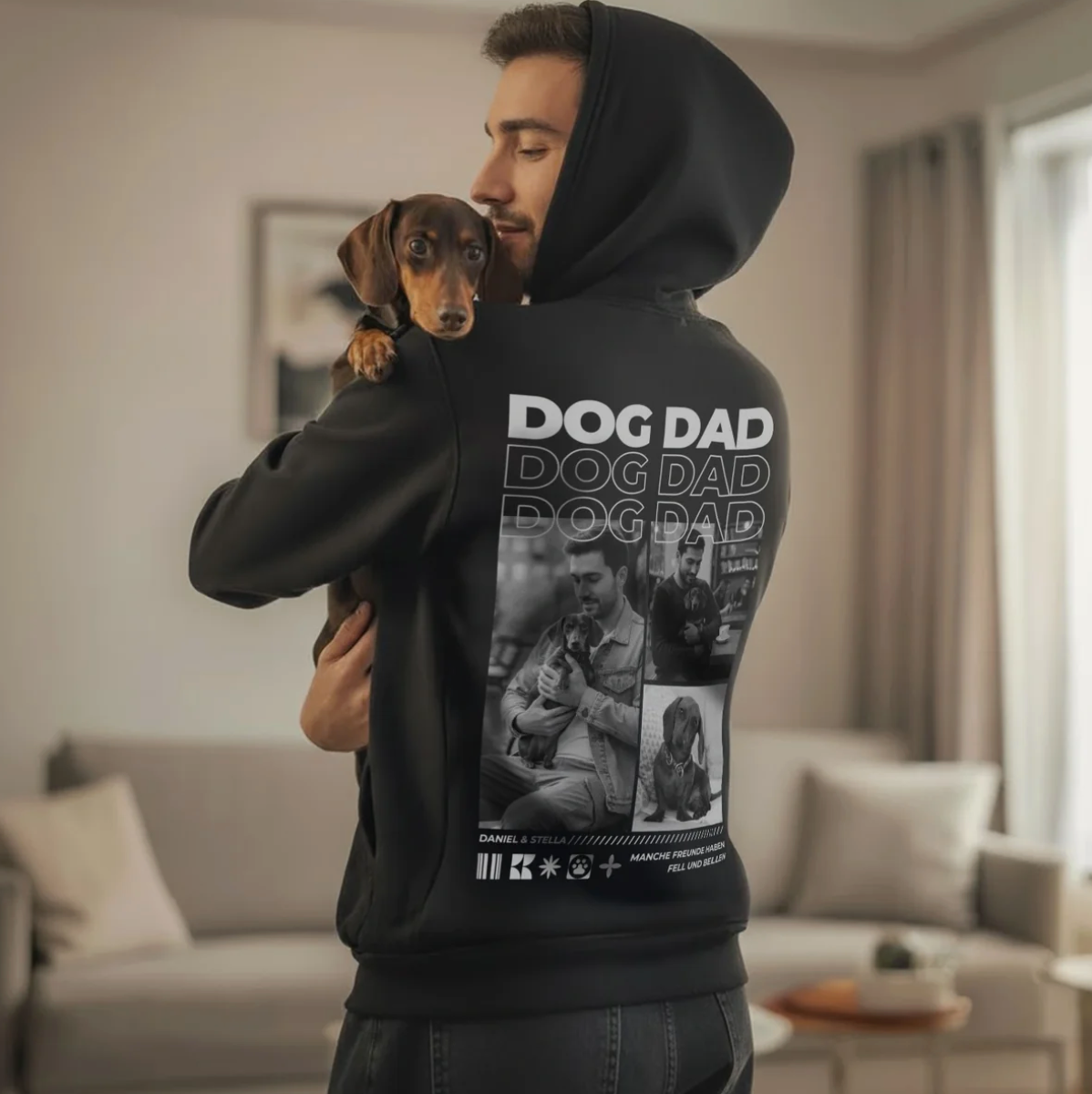 Schwarzer Hoodie mit aufgedrucktem "DOG DAD" und Fotomotiven von Hundebesitzern. Der Träger hält einen kleinen Hund.
