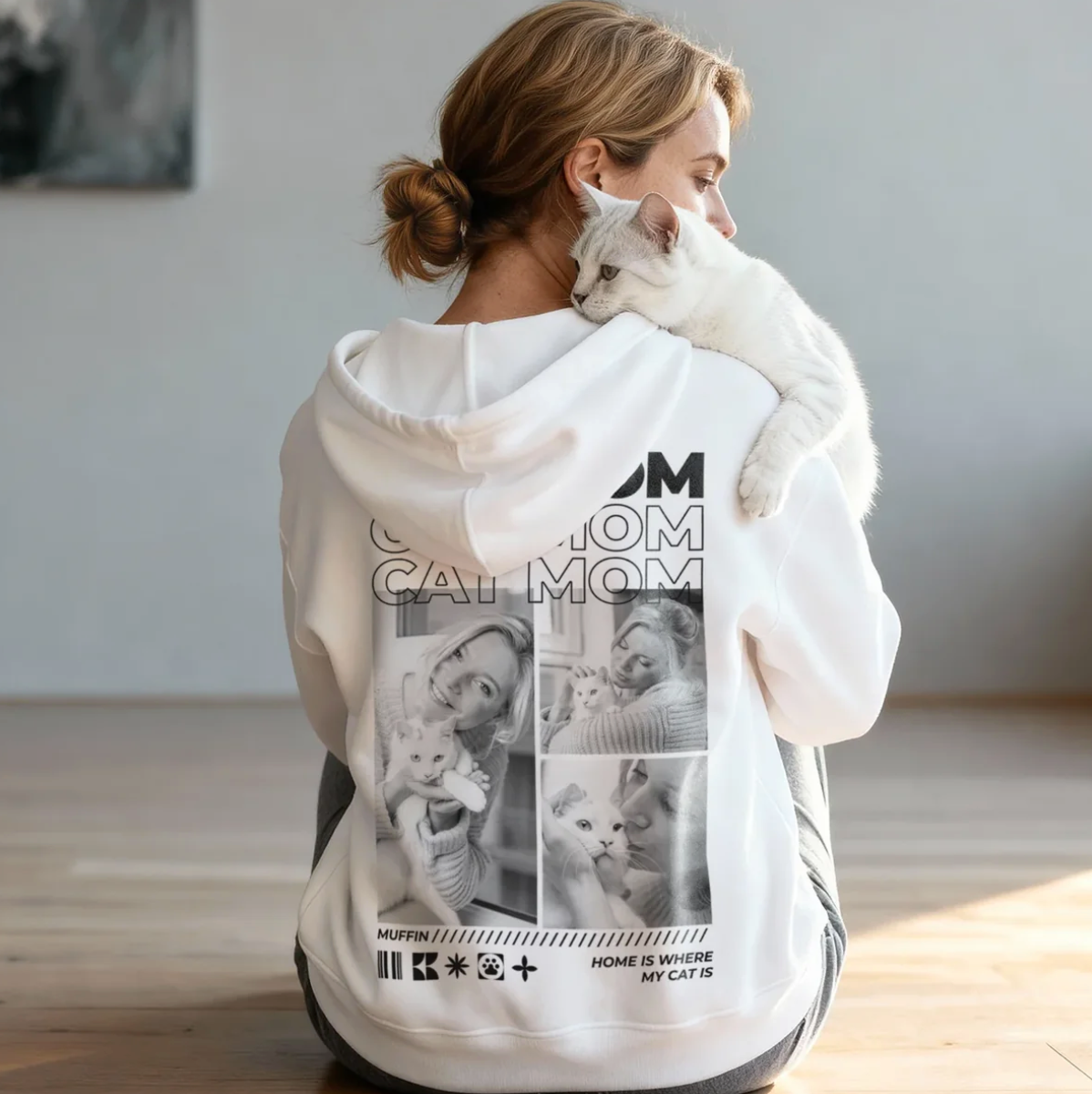 Personalisierter weißer Hoodie mit Aufdruck "Cat Mom" und Bildern von Katzen. Trägerin hält eine Katze.