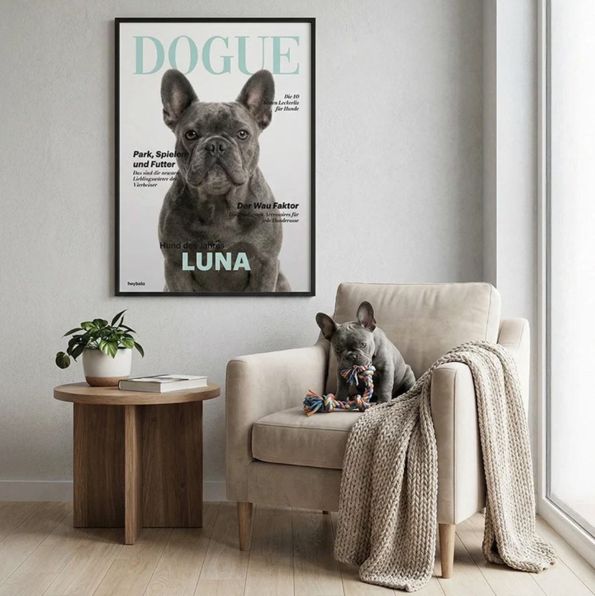 Personalisierte Wanddeko mit Poster eines Hundes, braune Couch, Blumentopf und Spielzeug auf einem Tisch.