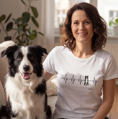 Weißes T-Shirt mit Herzschlag-Design und Hundemotiv, Personalisierung möglich. Frau sitzt mit Hund auf einem Sofa.
