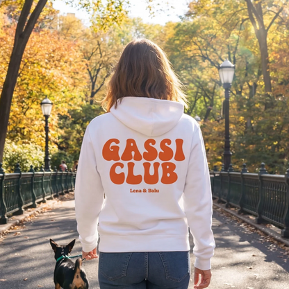 Weißer Hoodie mit dem Aufdruck "Gassi Club" und "Lena & Balu" auf der Rückseite. Person läuft mit Hund im Park.