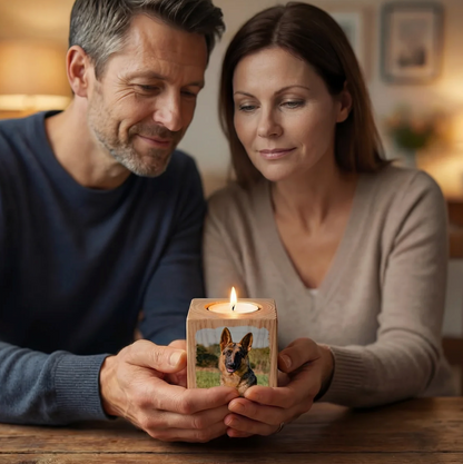 Personen halten gemeinsam einen personalisierten Kerzenwürfel aus Holz mit abgebildetem Foto und brennender Kerze oben.